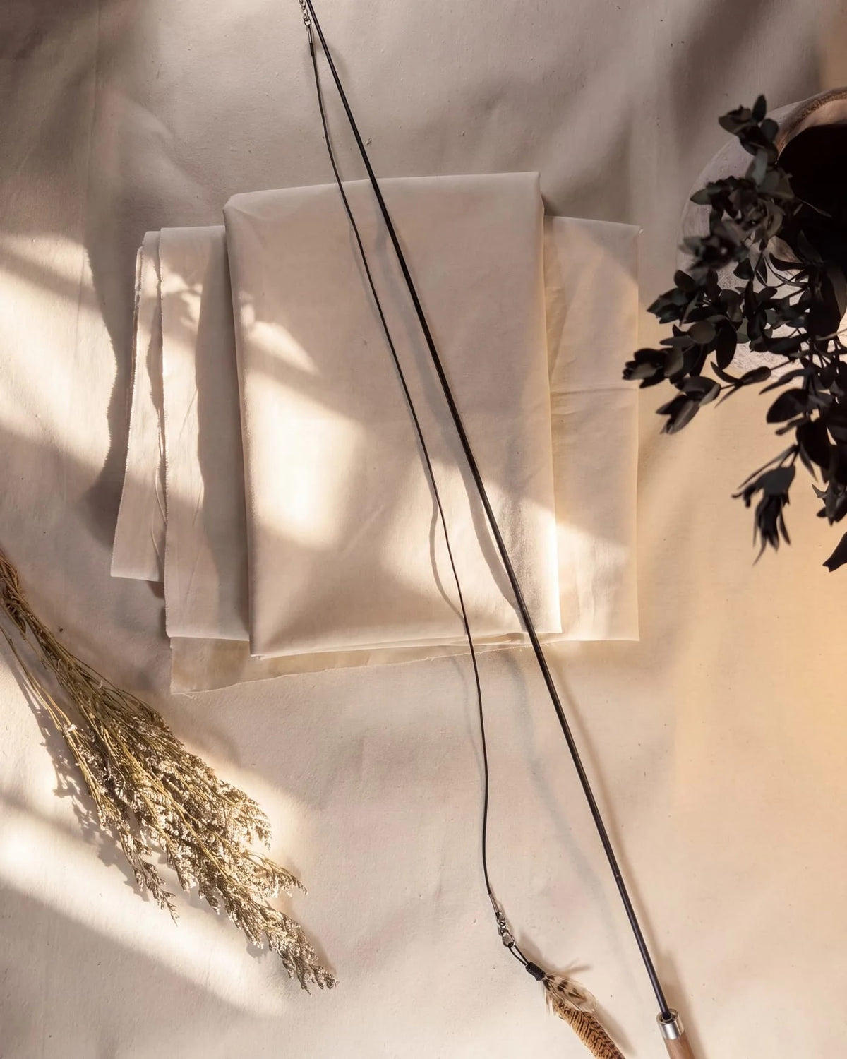 The Chaser laid out whole on folded linen - walnut handle, fibreglass rod, Dyneema cord and the Wren